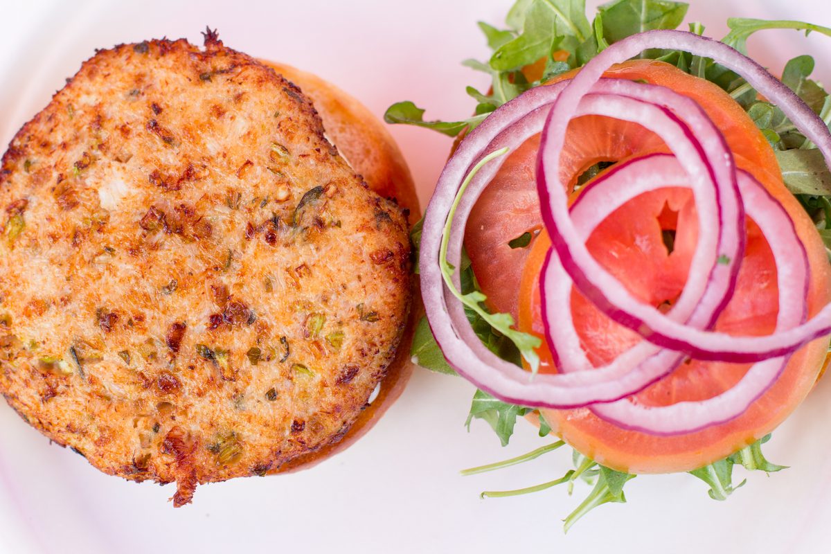 Dungeness crab cake sandwich on Acme bread with arugula and tomato